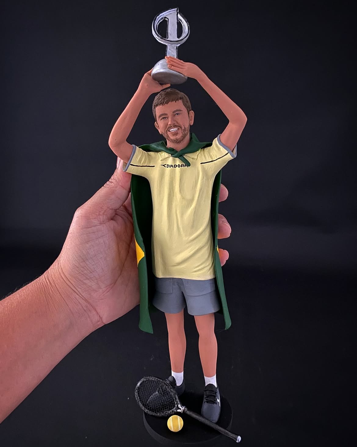 Miniatura 3D personalizada comemorando uma conquista no esporte, com taça e raquete